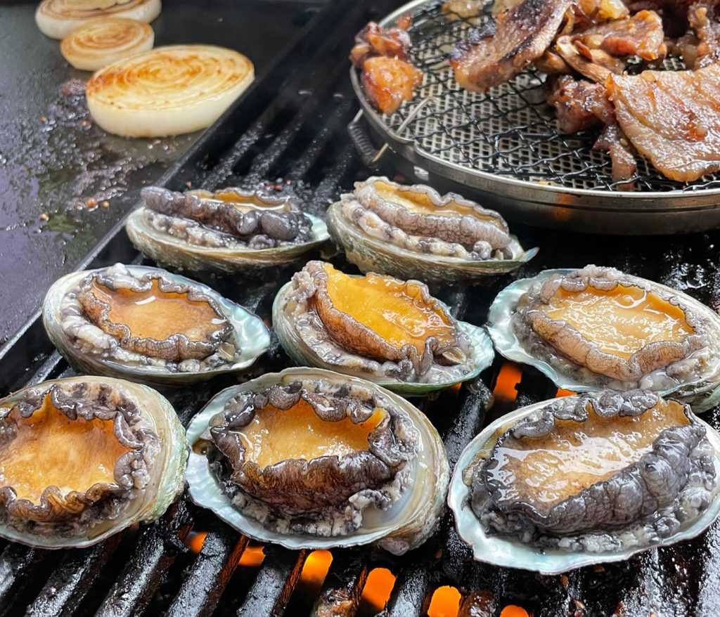 アワビが大量に網の上で焼かれています